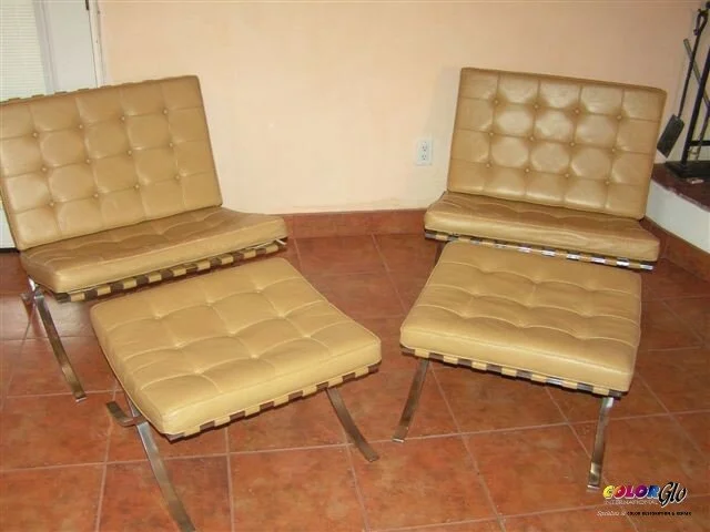 Two beige cushioned lounge chairs with chrome frames on a terracotta tile floor.