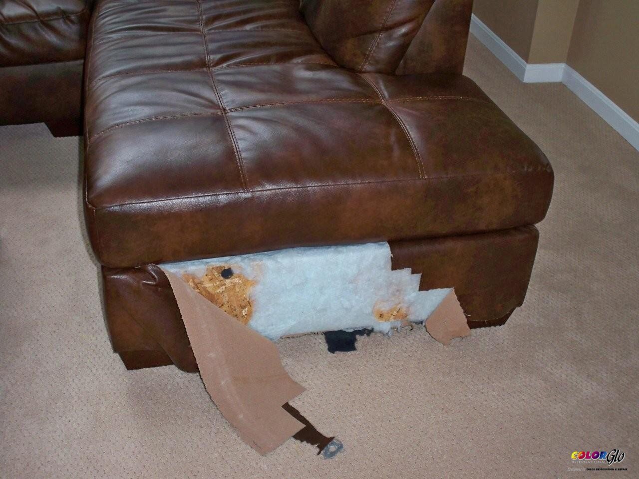 Close-up of a brown leather sofa with a damaged bottom corner revealing stuffing and torn upholstery.