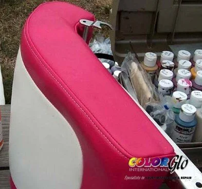 Close-up of a pink cushion on a white seat with spray paint bottles in the background.