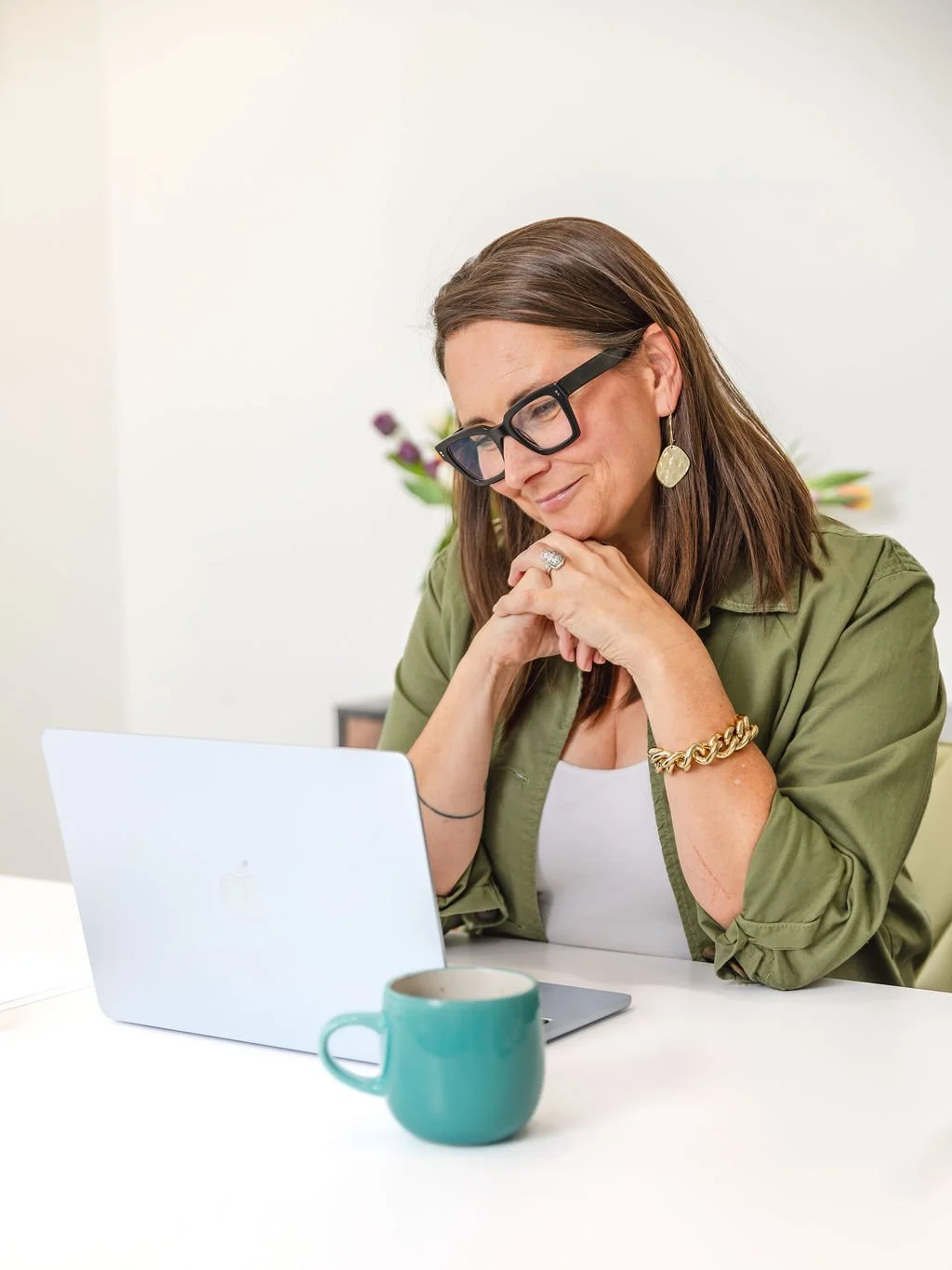 Courtney Schwartz, recruitment specialist of Rooted Hire smiling infront of her laptop