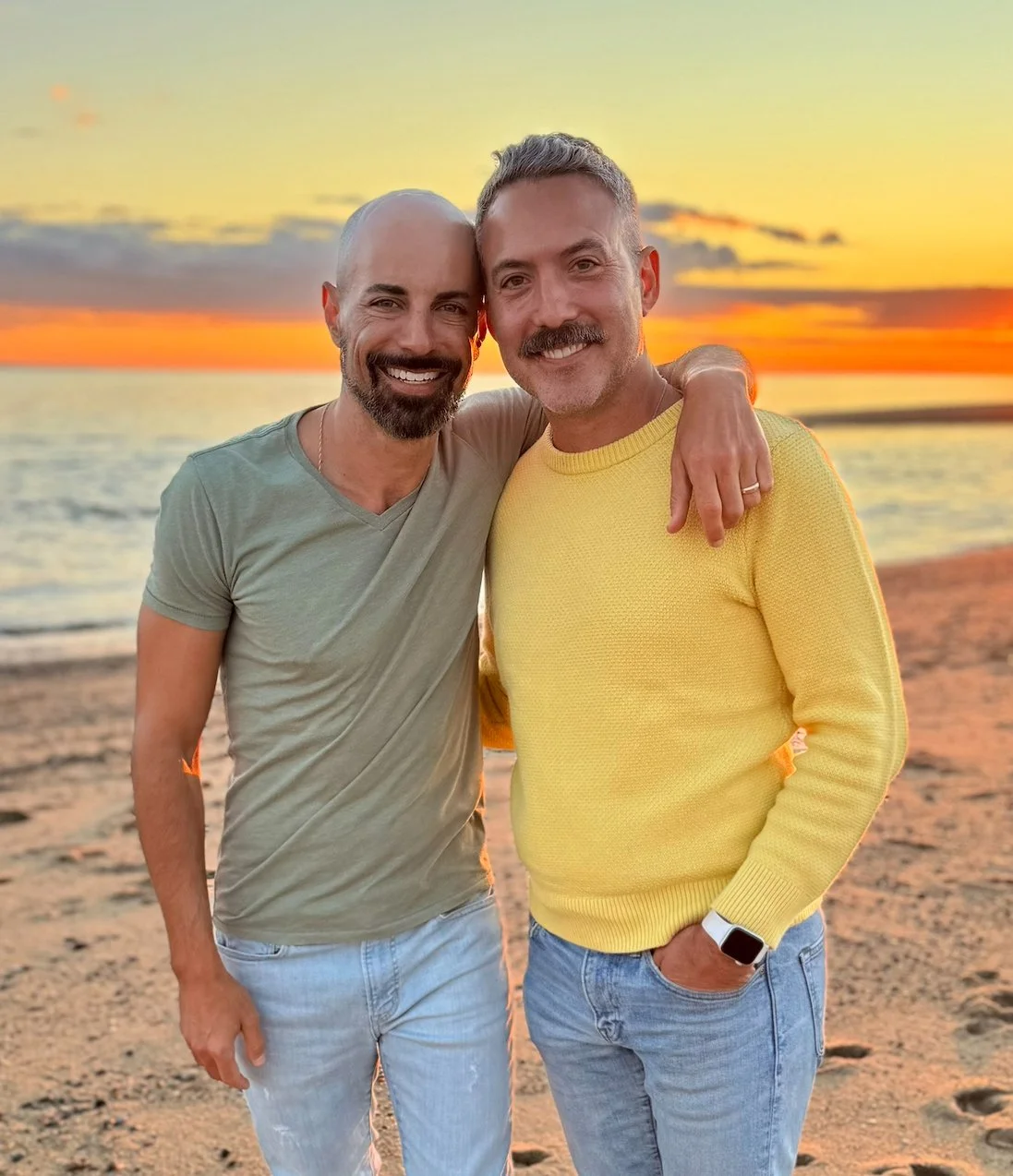 Happy customer of Jess Regan Creative Arts, a male couple on the beach with sunset in the background