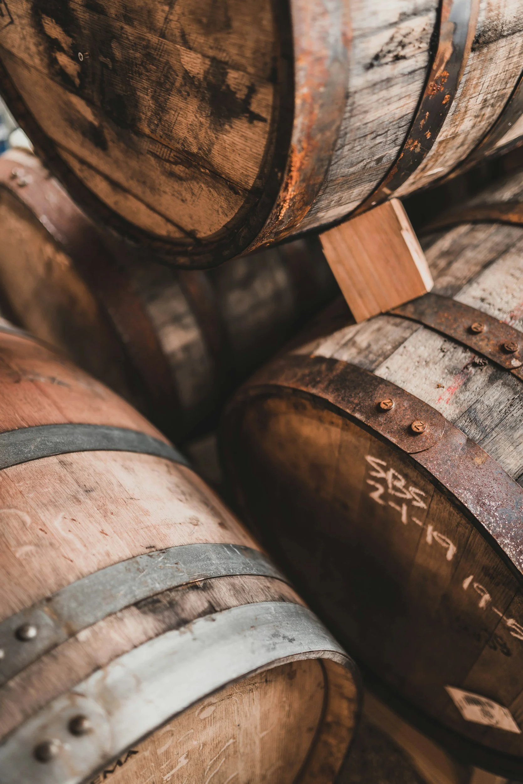 Close-up of wooden barrels with metal hoops stacked together.