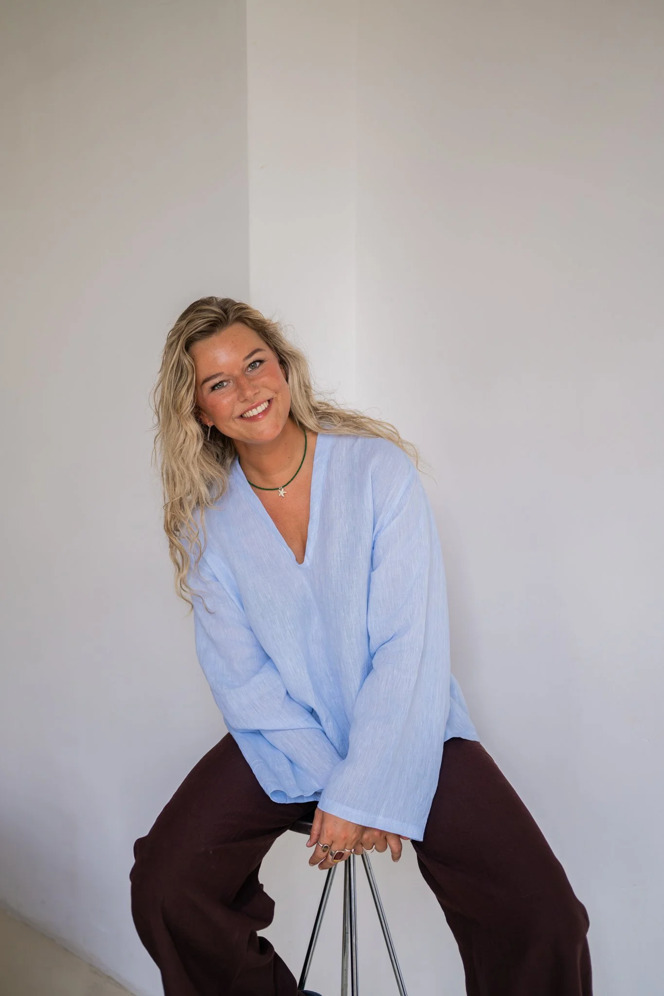 Professioneel branding portret van Céline Ronsse van Studio Cé in een lichtblauwe blouse.