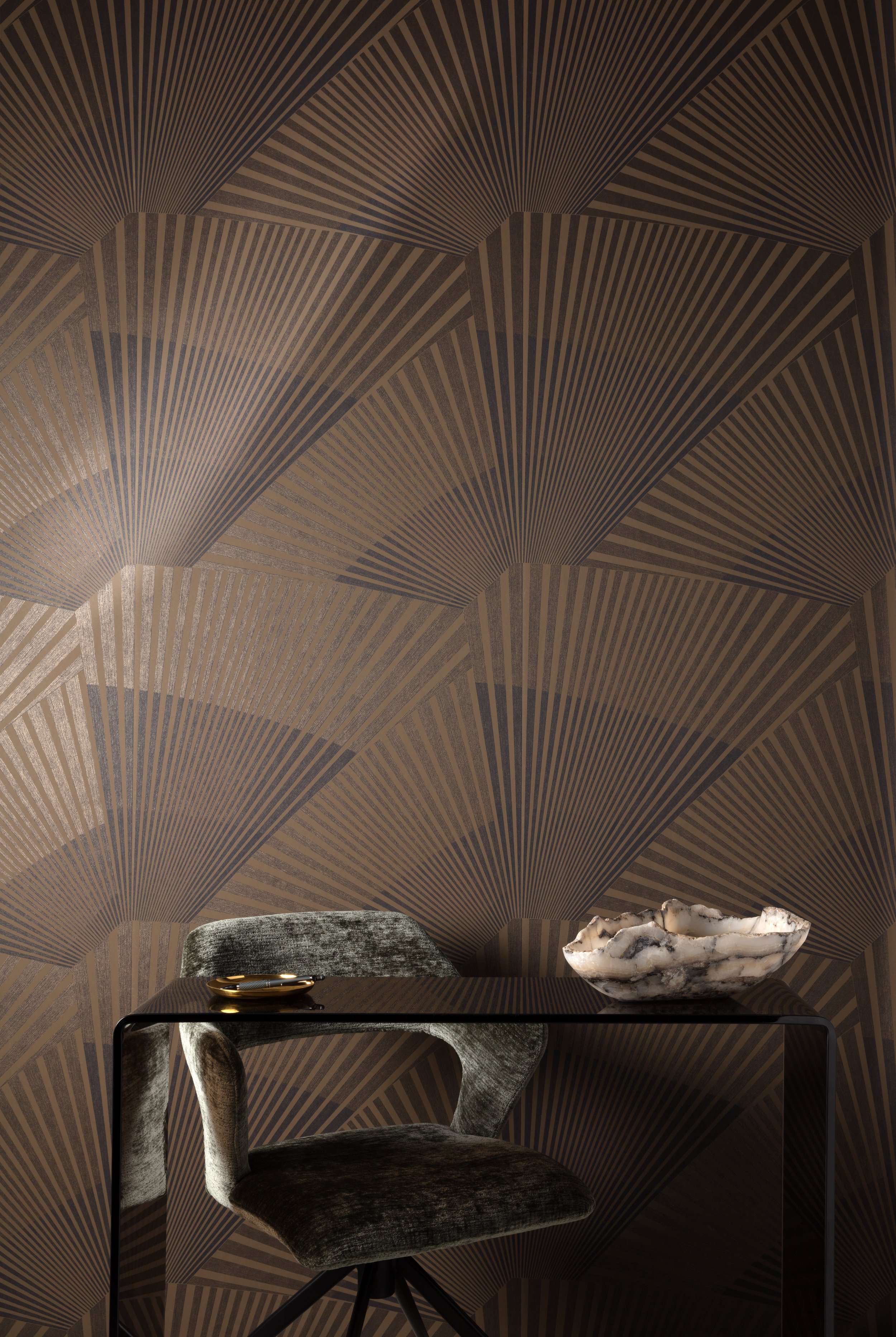 Stijlvol interieurdetail met een zwarte tafel, fluwelen stoel en decoratieve schalen tegen een geometrische wand.