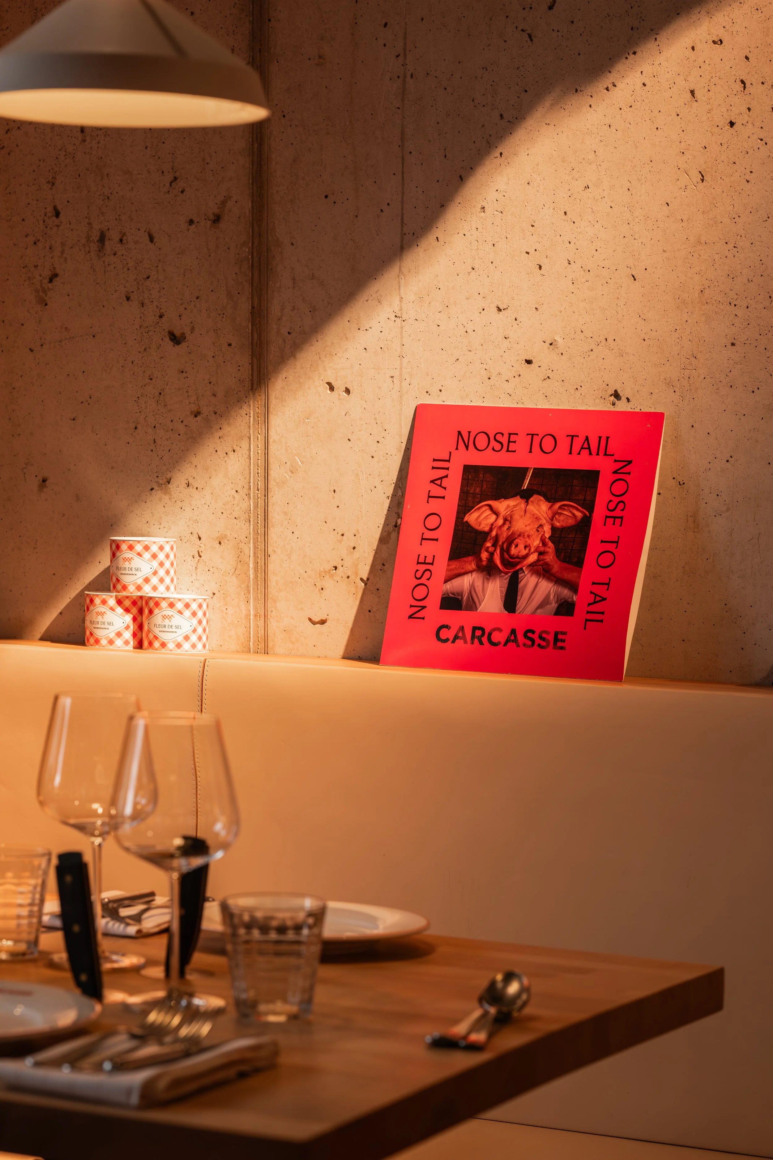 Sfeervol gedekte restauranttafel met wijnglazen, servies en warme verlichting bij Carcasse.