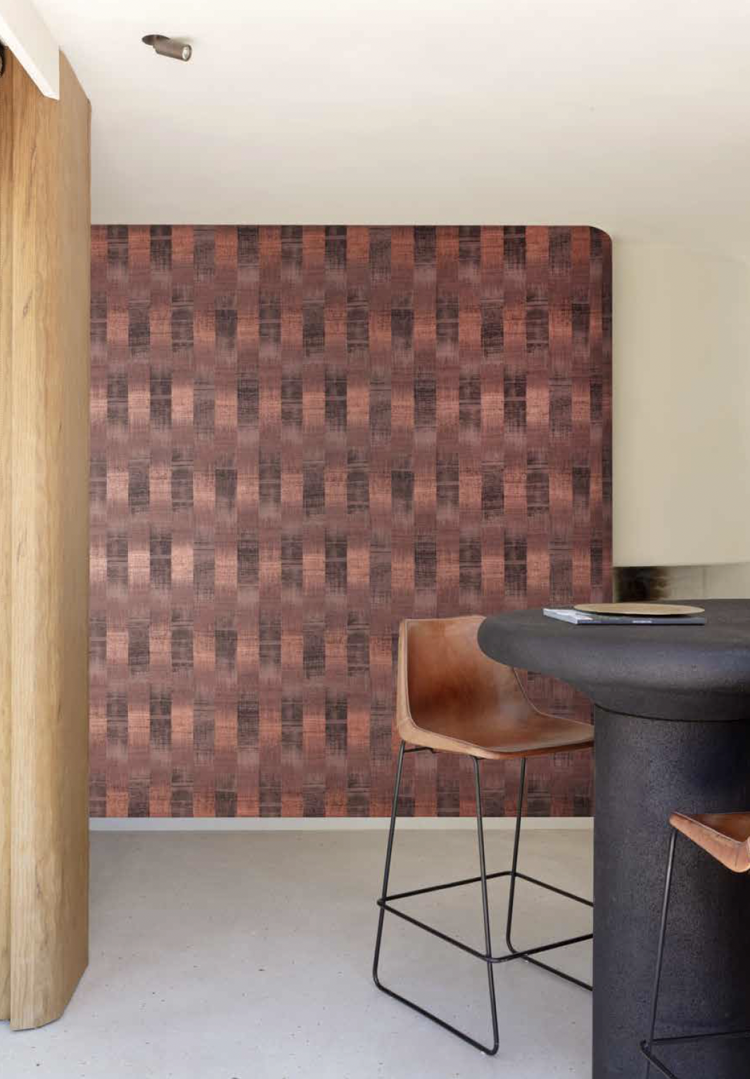 Modern interieur met rode patroonwand, ronde tafel en een combinatie van houten en lederen stoelen.