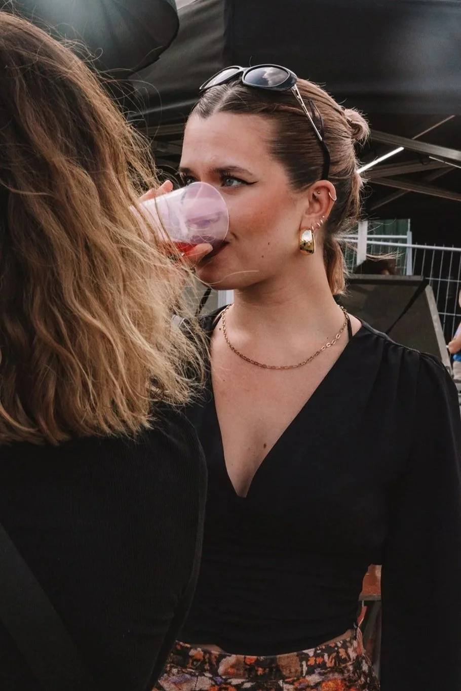 Spontaan moment tussen twee vrouwen tijdens een feestelijk buitenevenement.