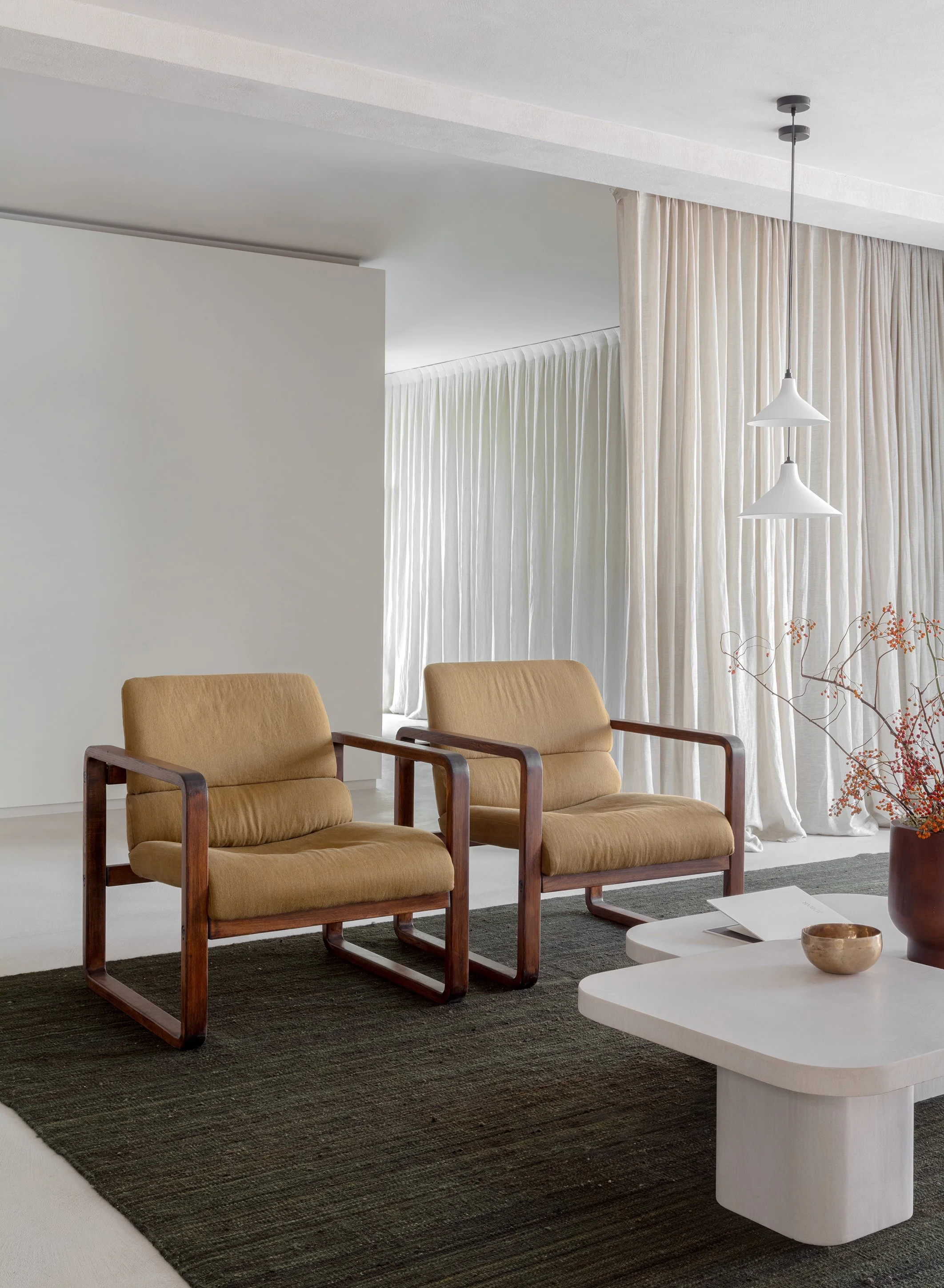Professionele interieur fotografie van een lichte woonkamer met beige fauteuils en een minimalistische inrichting.