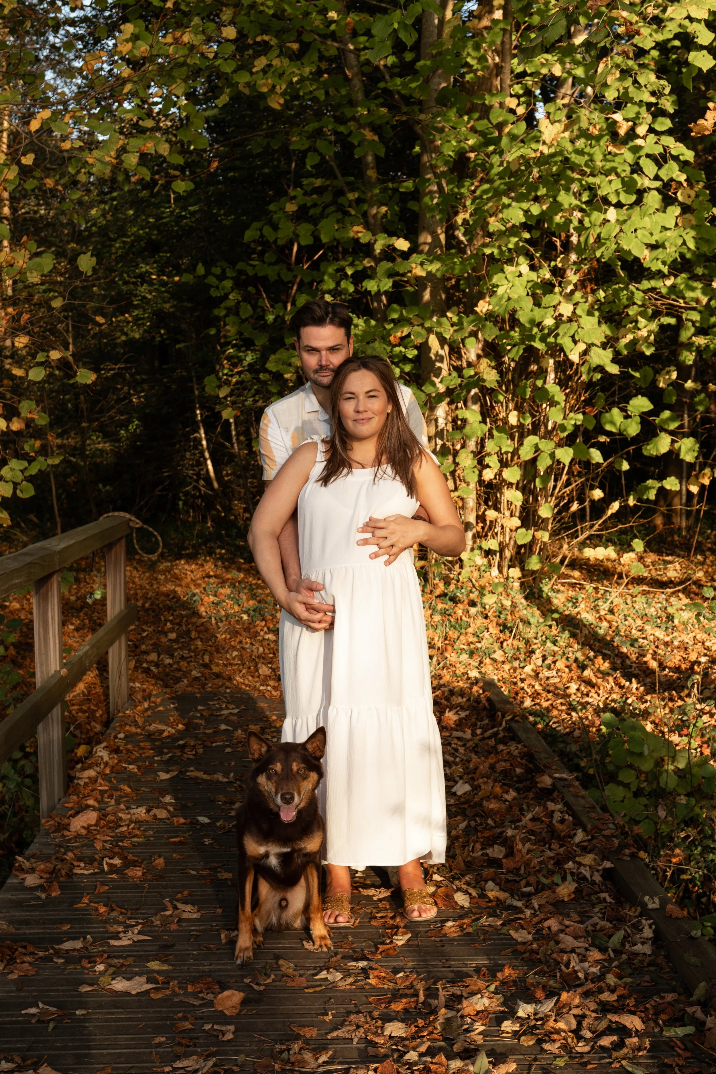 Zwanger koppel deelt een liefdevol moment tijdens een zwangerschapsshoot in het bos.