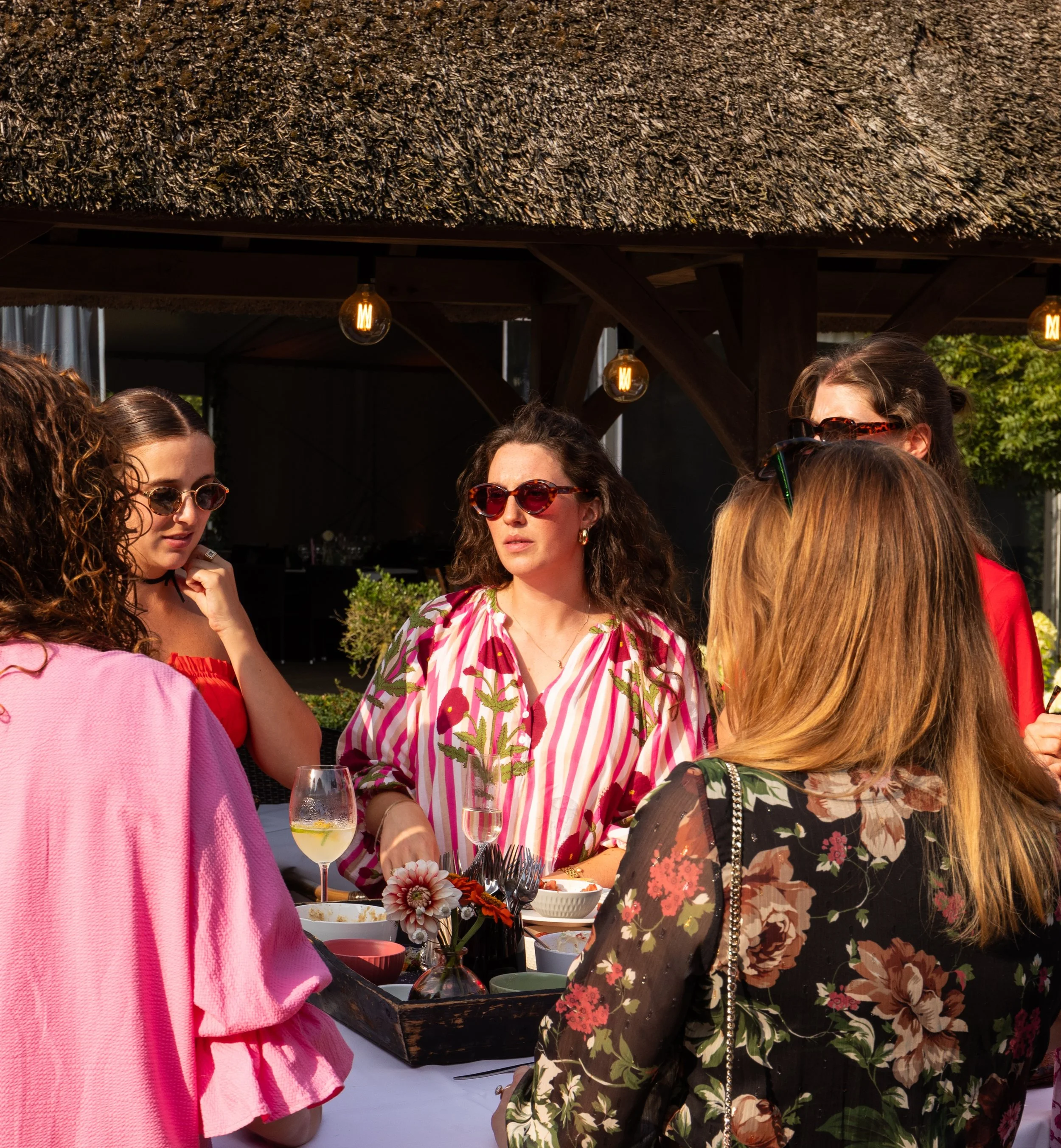 Vrouwen genieten samen van eten en drinken tijdens een sfeervol buitenevenement.