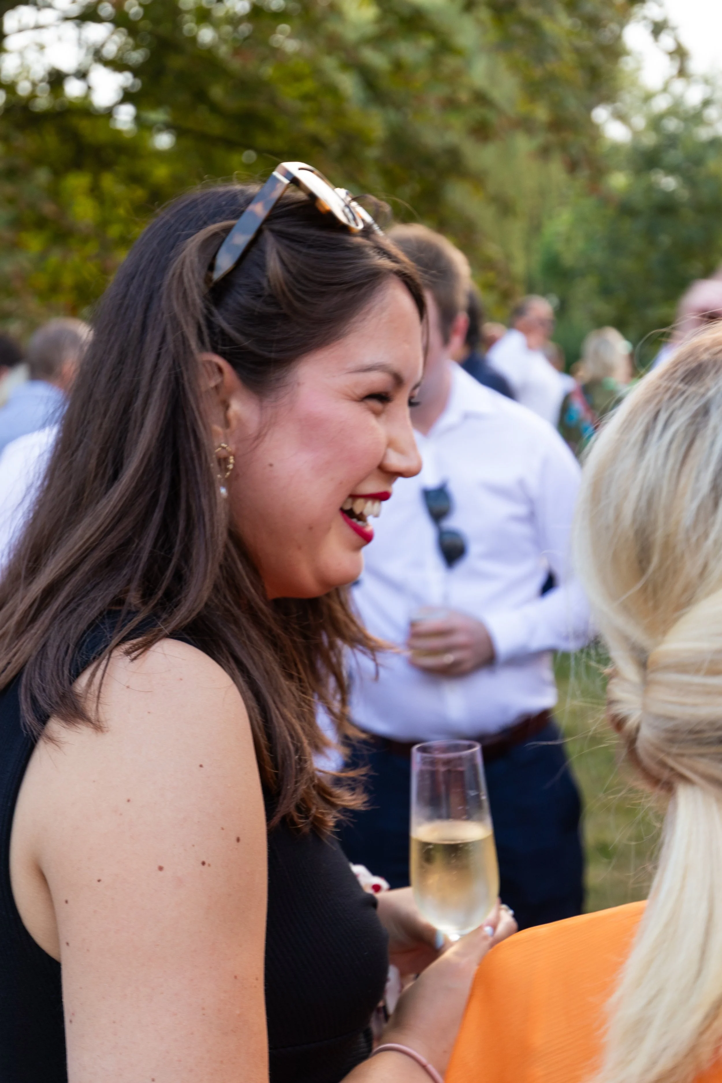 Twee vrouwen praten en lachen samen met een glas wijn tijdens het familiefeest.