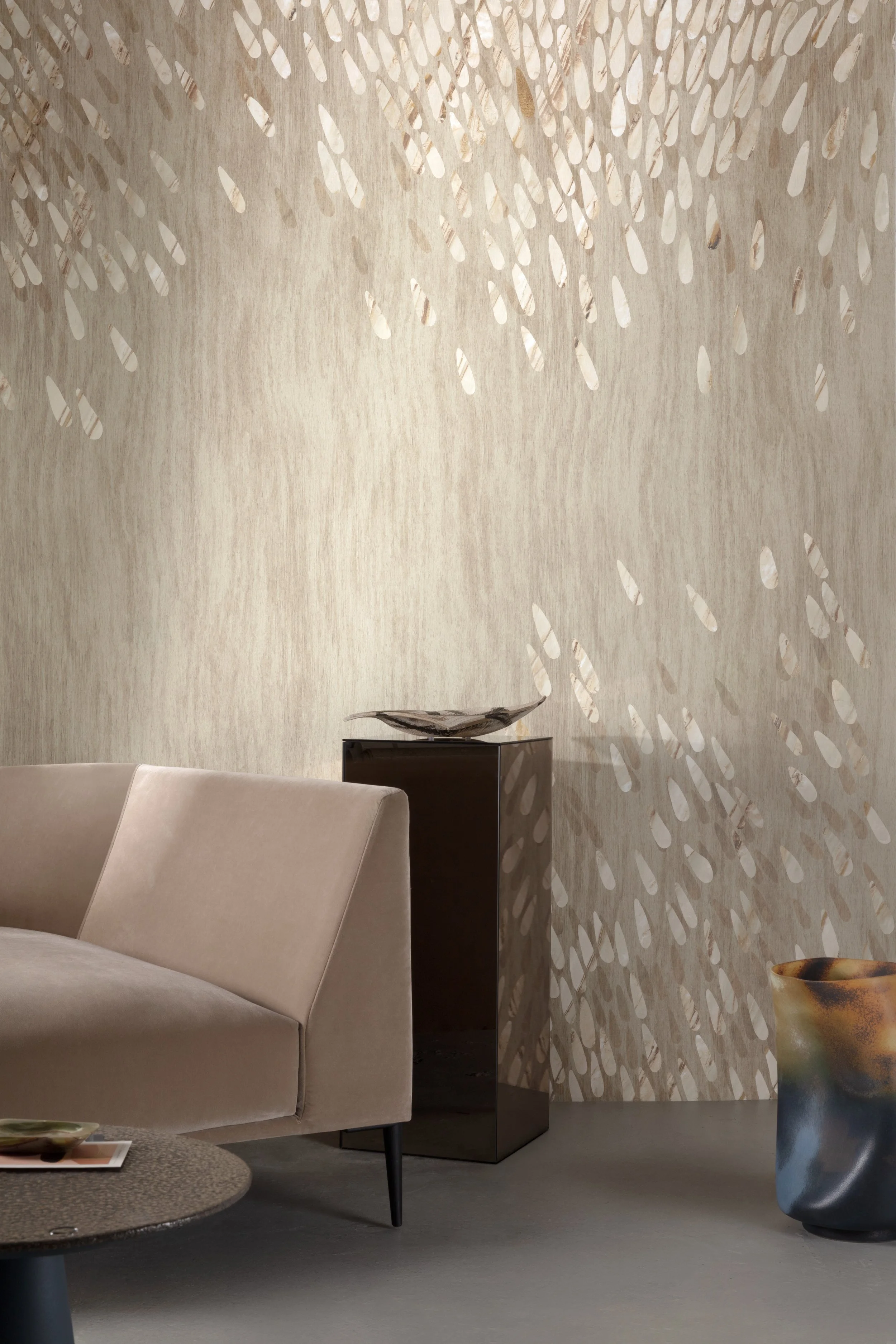 Moderne woonkamer met een beige zetel, ronde salontafel en sfeervol lichtspel op de wand.