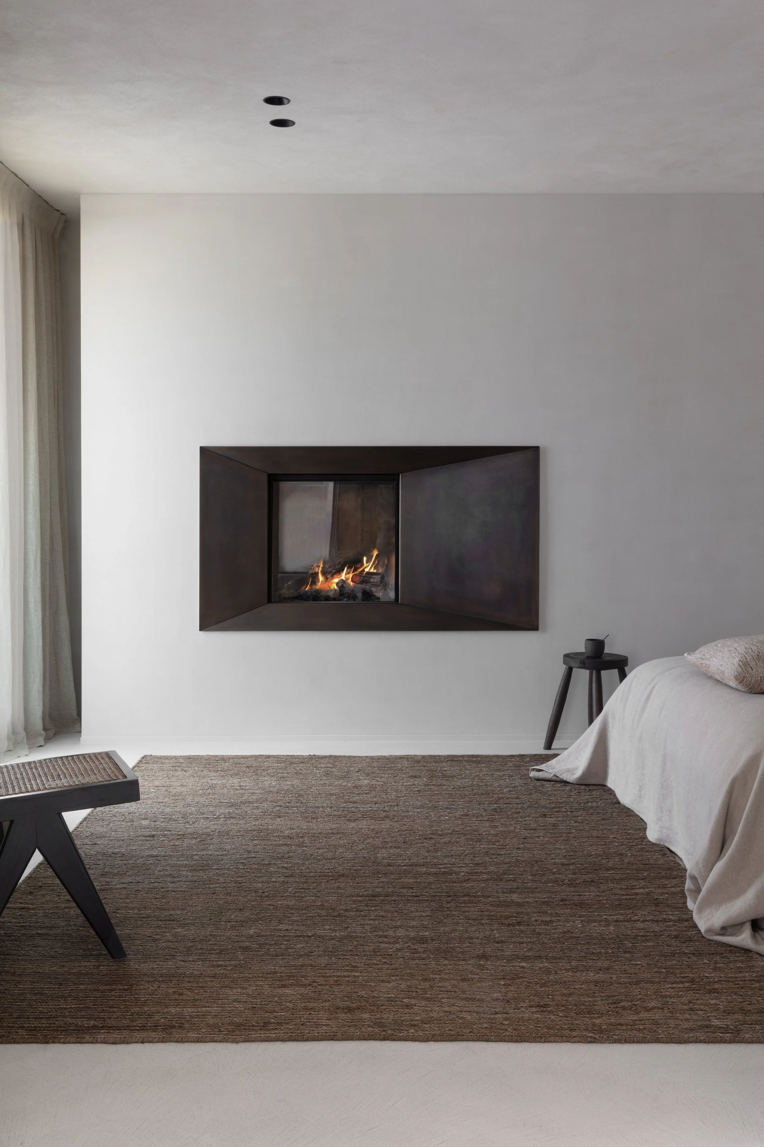 Minimalistische slaapkamer met een moderne hoekhaard, warme houttinten en zacht natuurlijk licht.