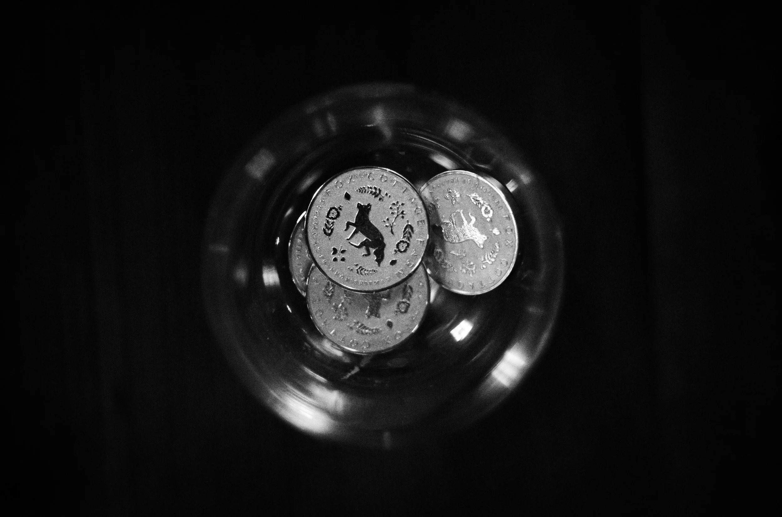 An upside-down clock is reflected within a dark circular surface.