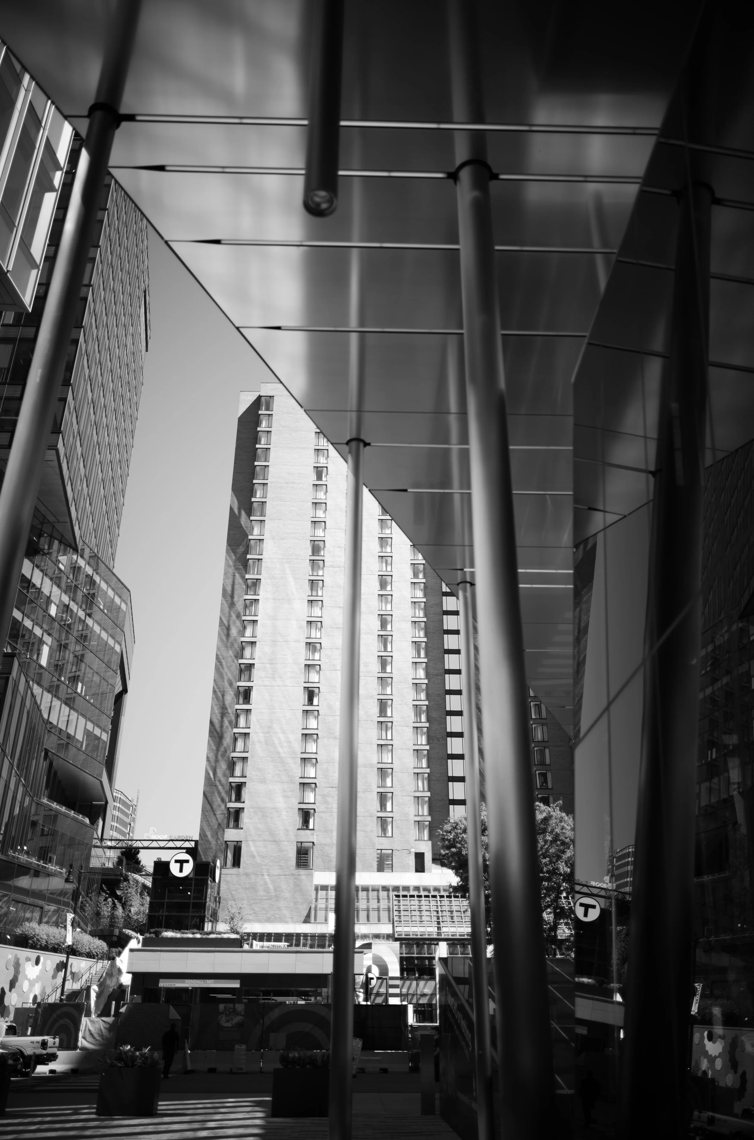 Tall buildings frame a narrow city view beneath an overhanging facade.