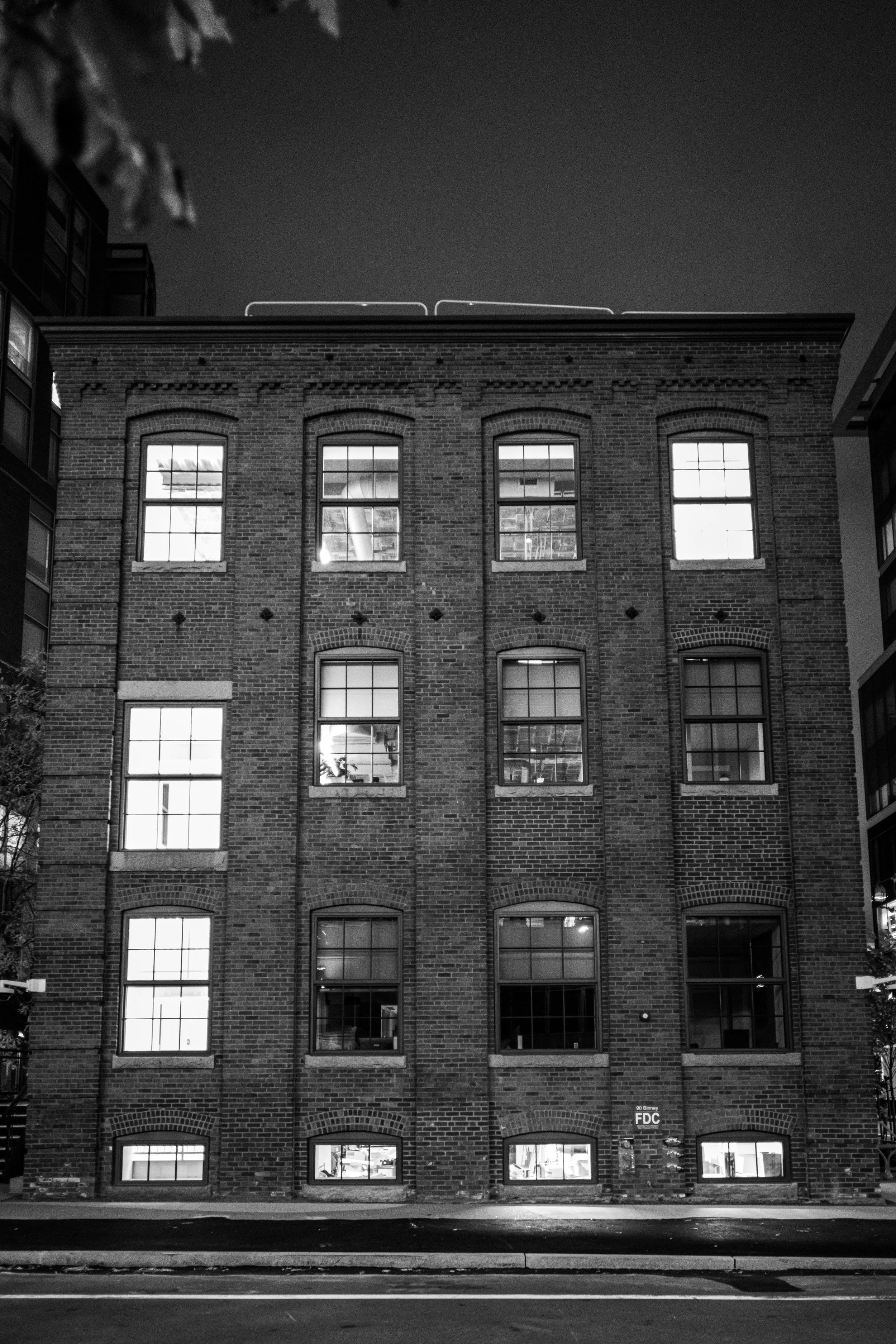 Rows of illuminated windows punctuate a brick building at night.
