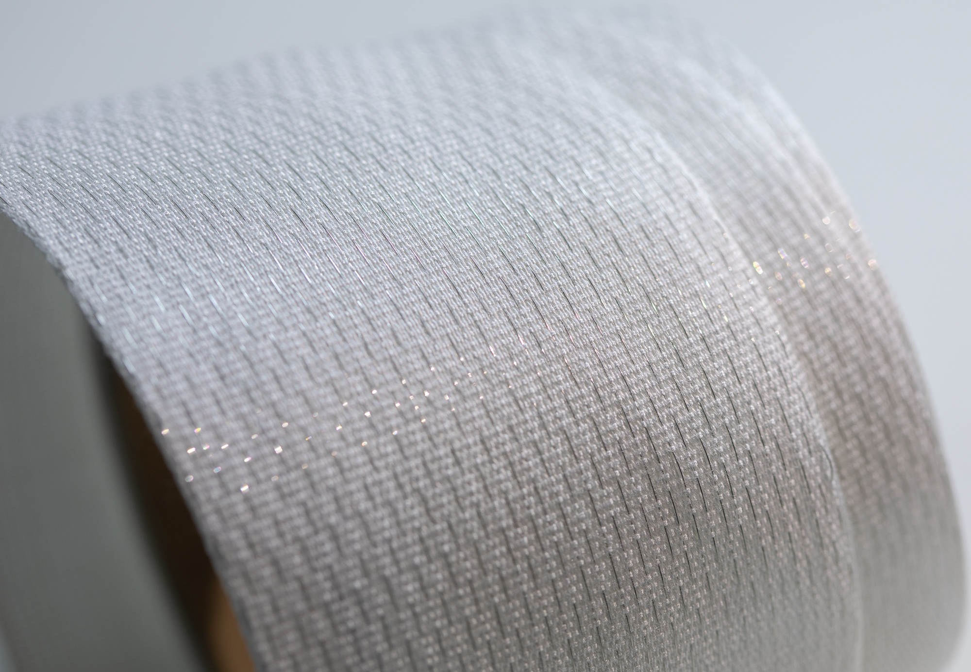 Close-up of a textured, metallic silver surface with fine parallel lines.