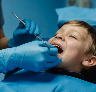 Child receiving dental examination from a dentist with gloves