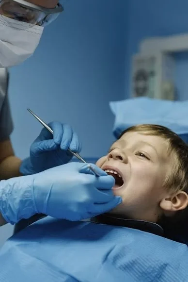 Child receiving dental checkup from a dentist in a clinic.