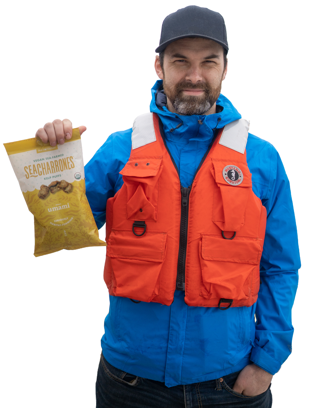 A man wearing a black cap, blue jacket, and orange life vest holding a bag of seaweed kelp puffs.