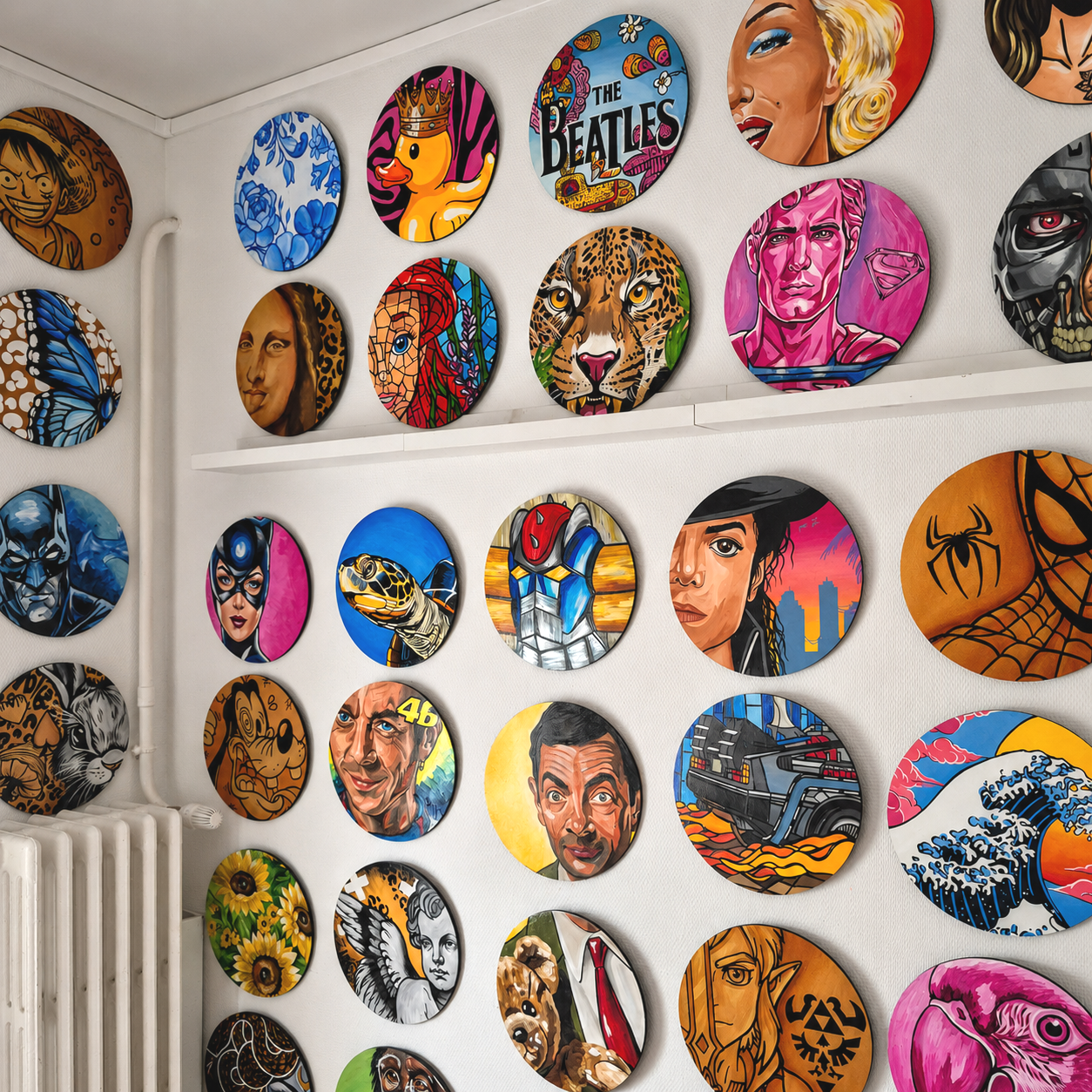 Une collection d'œuvres d'art sur des panneaux ronds accrochés à un mur, représentant des portraits de célébrités, des personnages de bande dessinée, des animaux, des super-héros, et des scènes colorées.