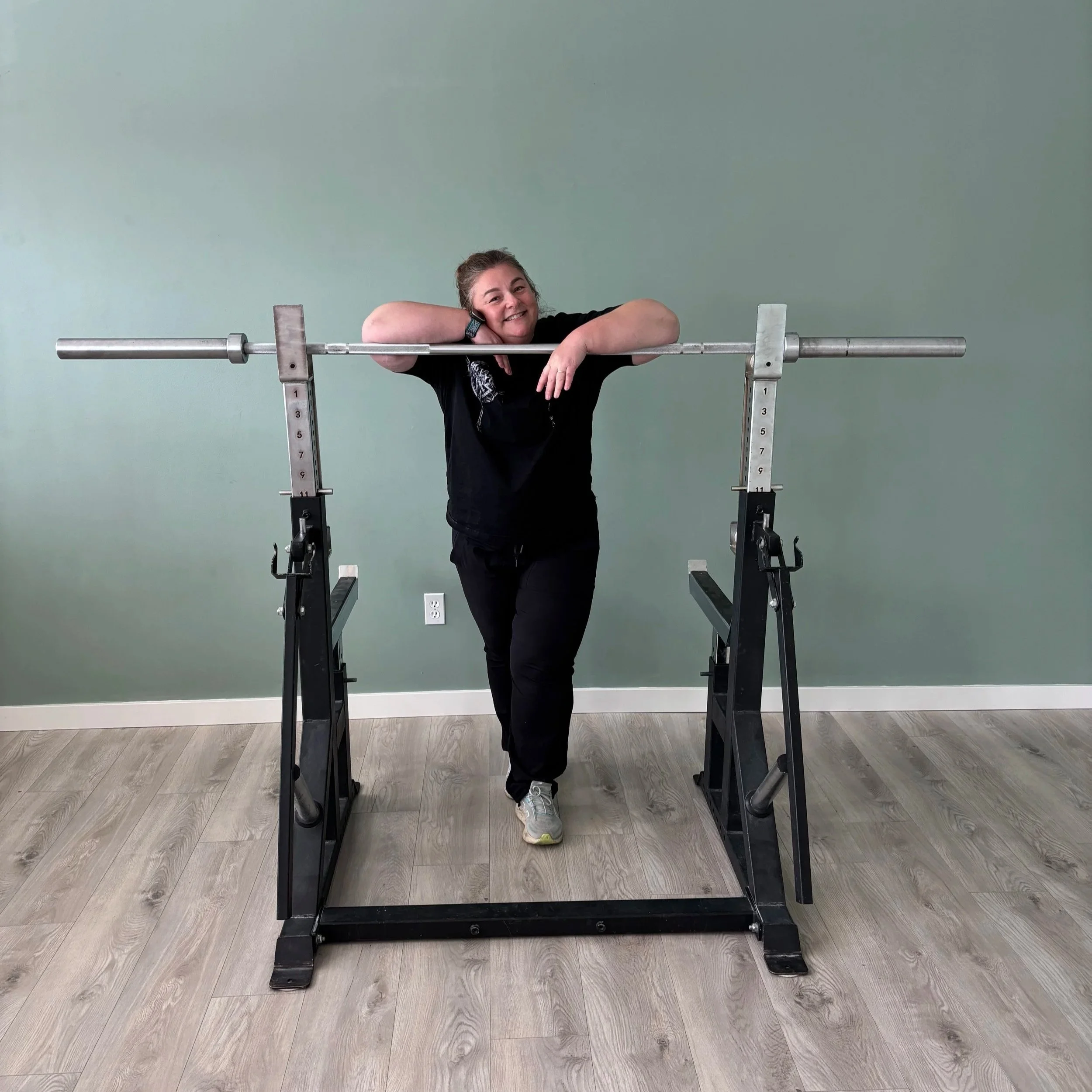 Laura posing behind bar bell rack
