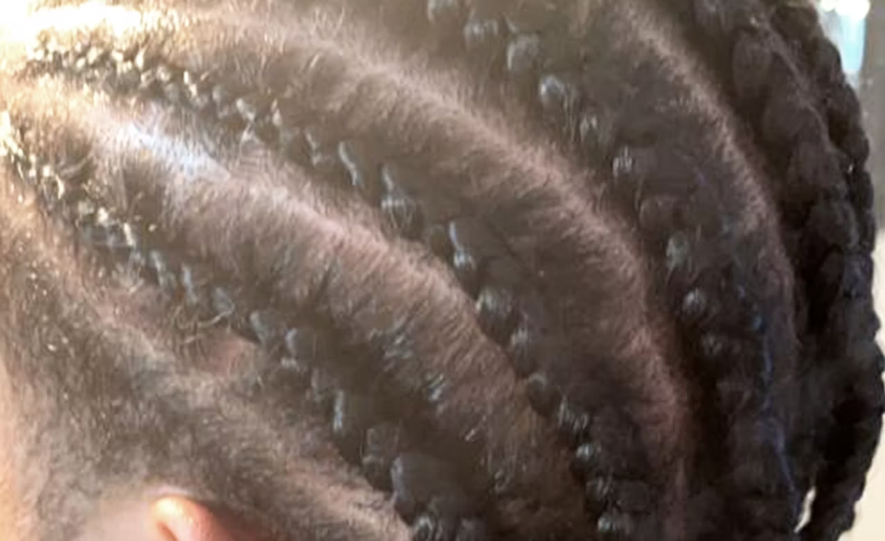 Close-up of a person's hair styled in tight braids.