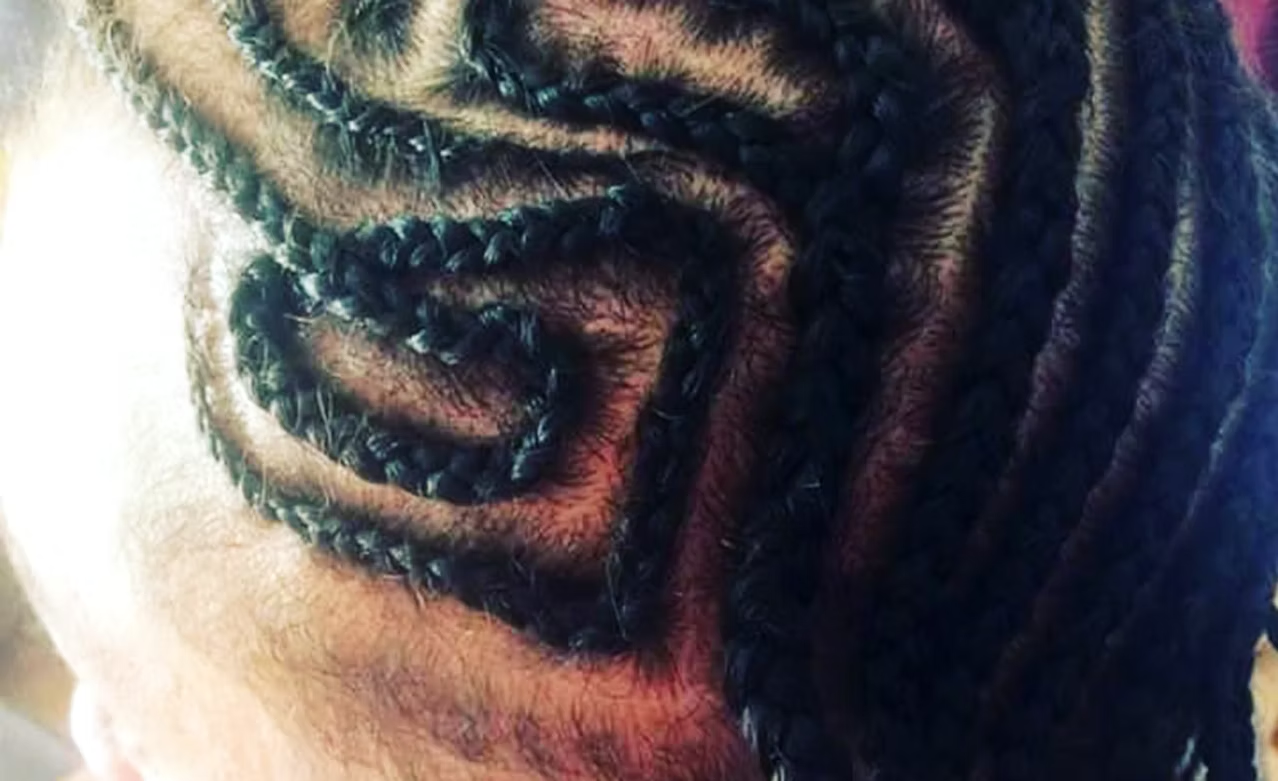 Close-up of tightly coiled black dreadlocks on a person's head.