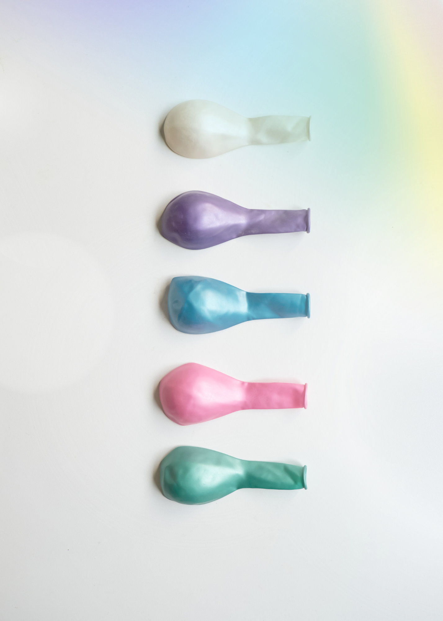 Colorful inflated balloons arranged vertically on a white background.