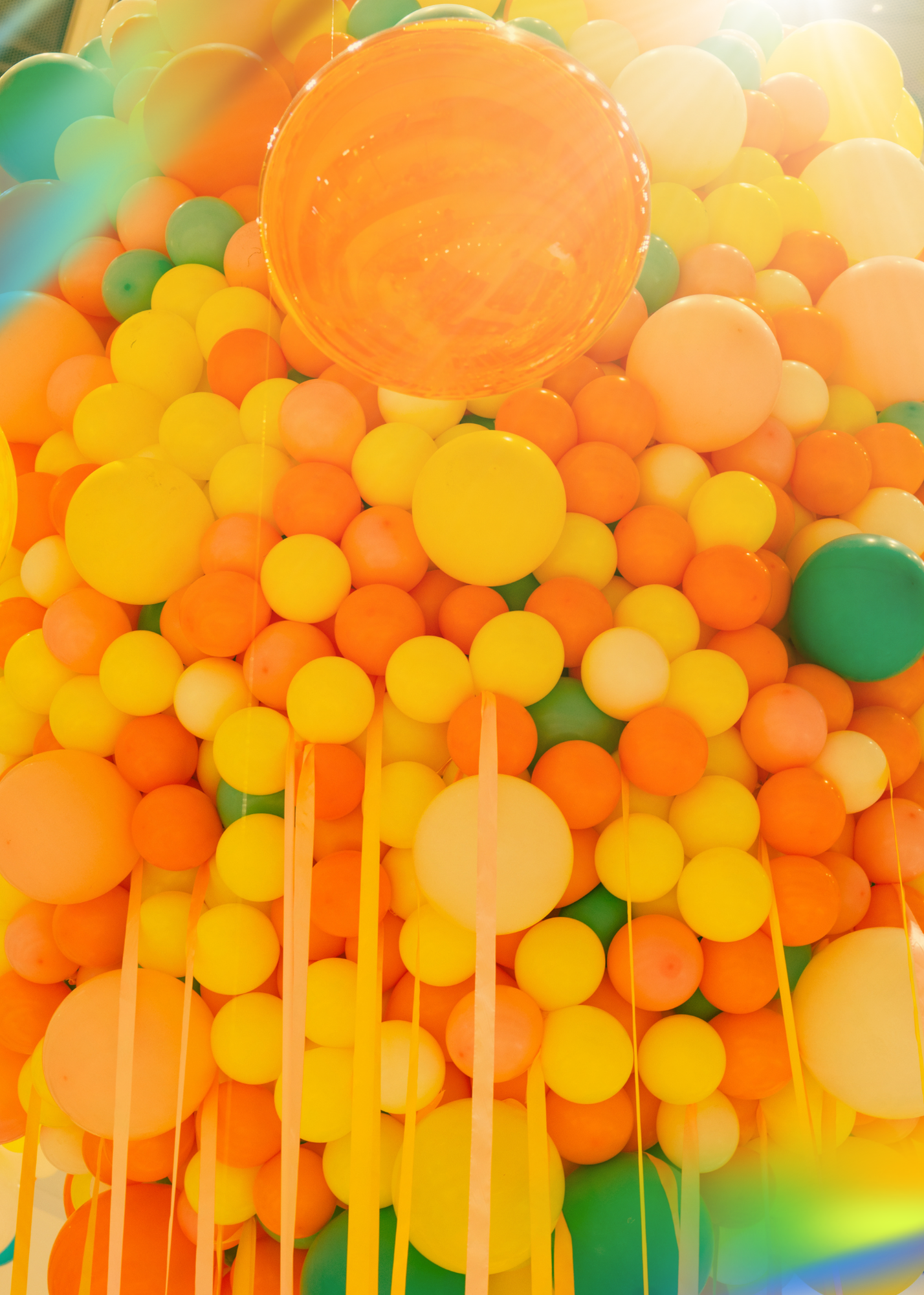 A projection of a jumble of colorful plastic balls, primarily in yellow, orange, and green, with some with yellow sticks or rods among them.