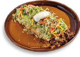 Plate of shredded beef tacos with lettuce, cheese, sour cream, and vegetables