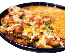 Close-up of a cast iron skillet filled with cheesy baked dip topped with sausage, chips, and chopped vegetables.
