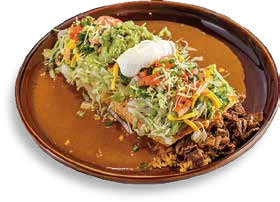 Tacos on a brown plate with lettuce, cheese, and sour cream.