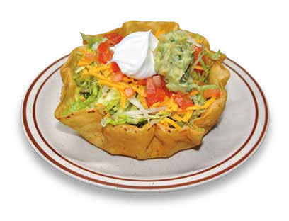 Taco salad in a tostada shell with lettuce, shredded cheese, tomatoes, sour cream, and guacamole
