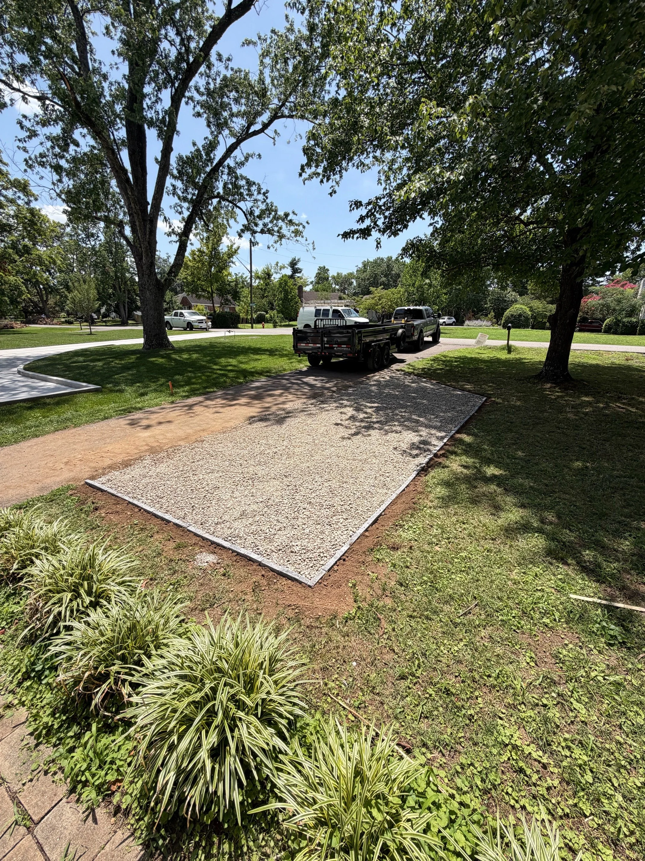 Completed gravel parking pad beside a driveway