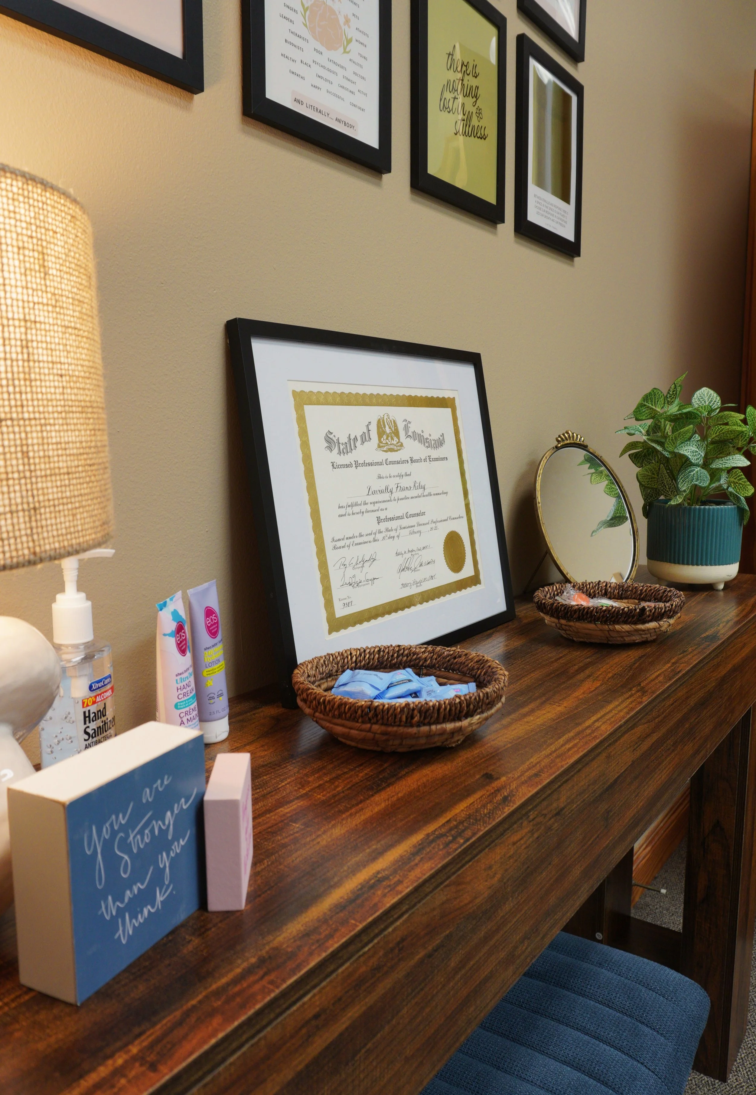 Warmly lit console with framed credentials and a plant