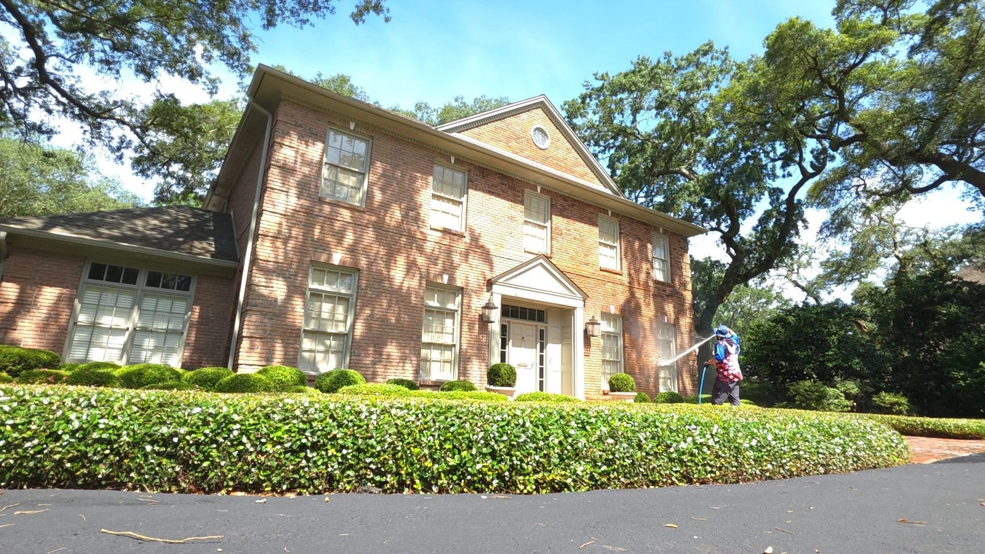 Professional softwash house washing service restoring the pristine exterior of a luxury brick home in Pensacola, Florida.