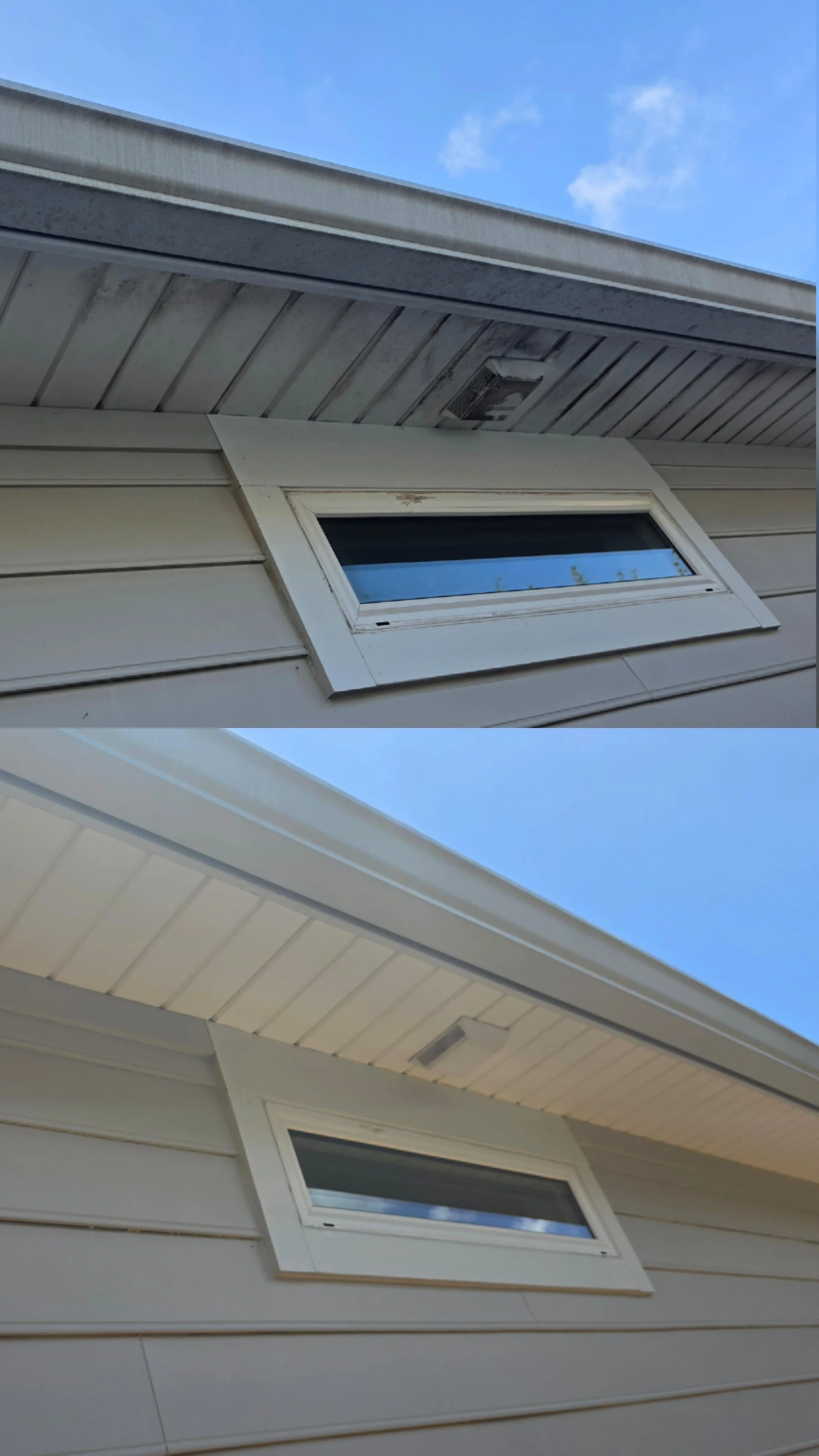 A close-up view of a house's exterior wall and roof, showing two small rectangular windows and part of the soffit, with a blue sky and some clouds overhead.