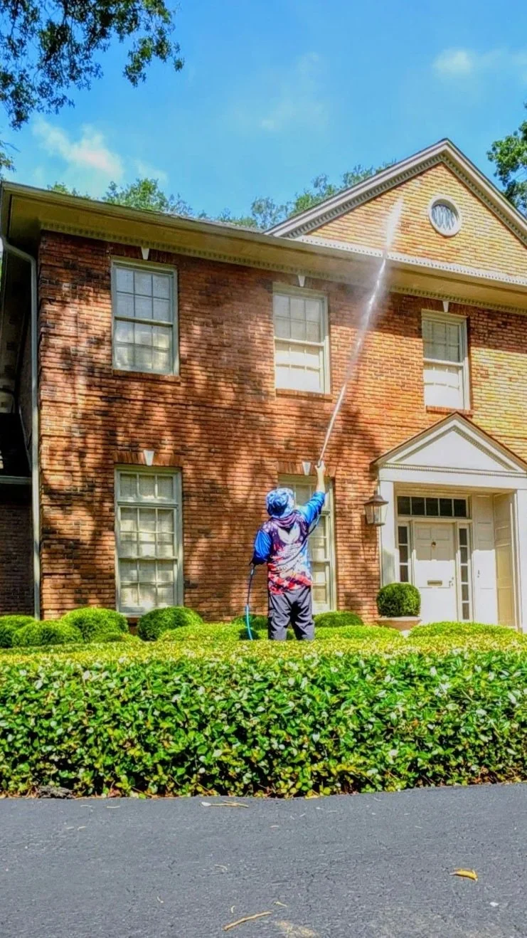 Professional softwashing and house washing services for a two-story brick home in Pensacola, Florida.