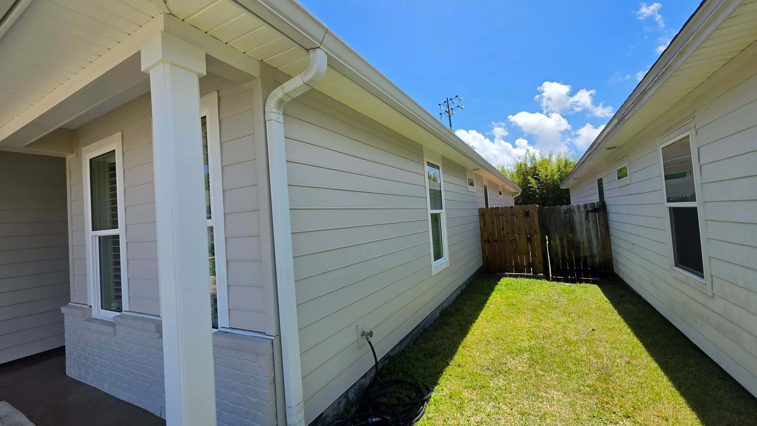 Finished low-pressure house washing results showing clean soffits, gutters, and siding.
