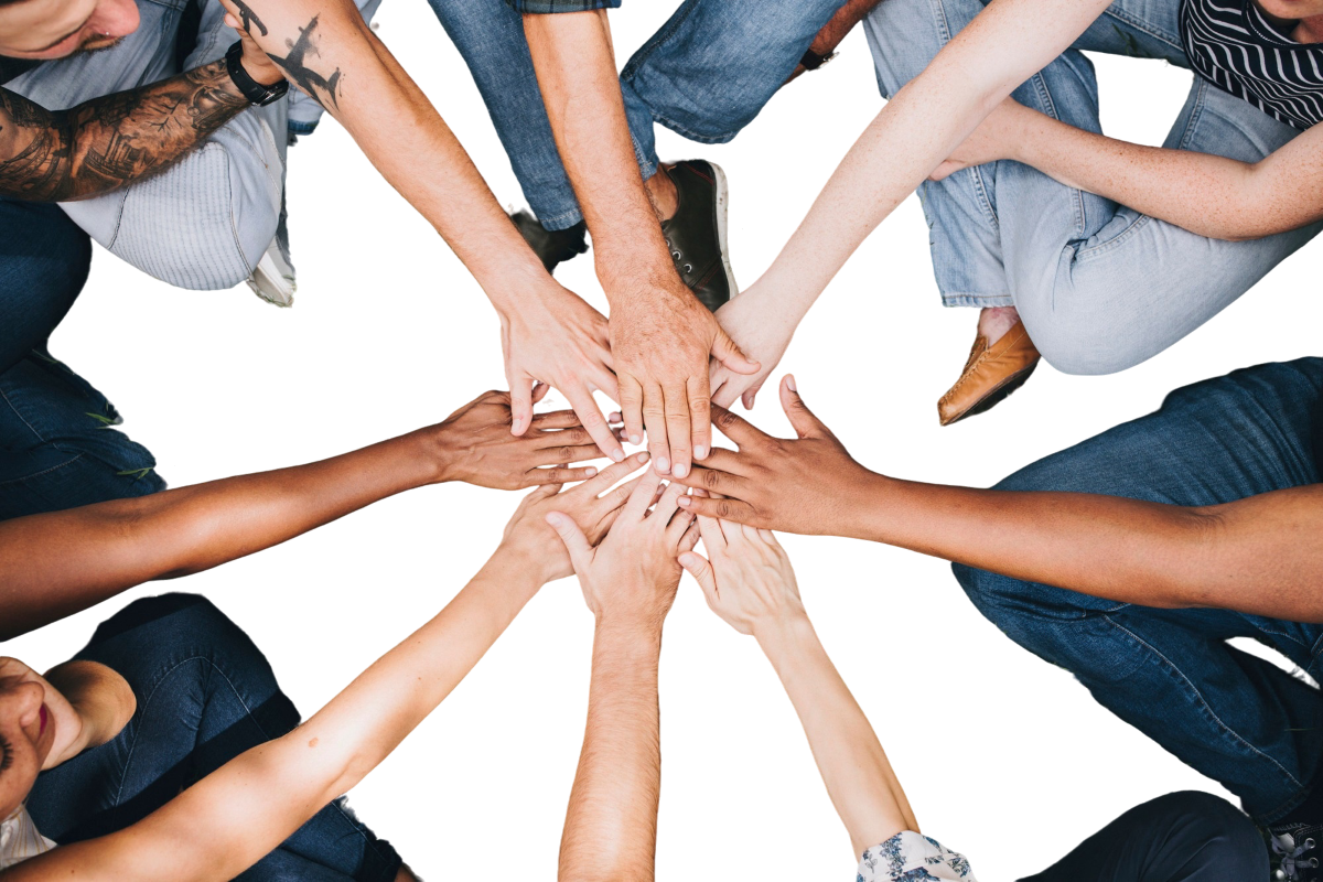 Multiple hands from diverse individuals placed together in a circle, symbolizing unity and teamwork.