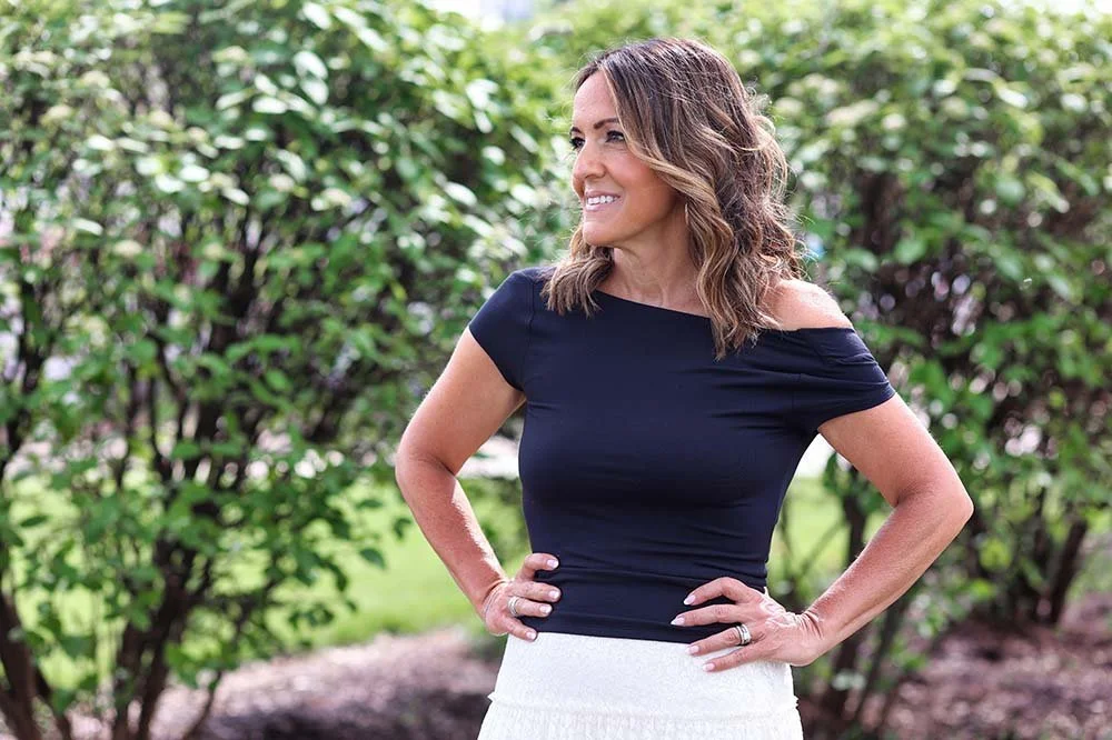 Maria Bullion standing outdoors with greenery in the background.