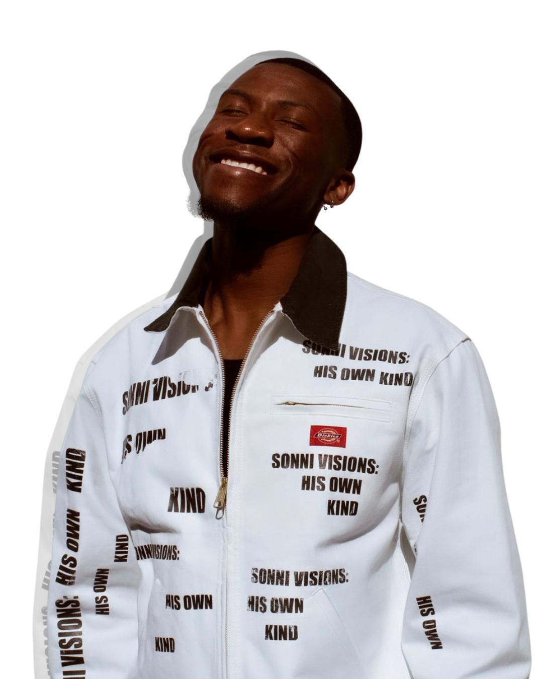 A smiling man with short hair wearing a white jacket with black text and a small red logo, standing against a plain white background.