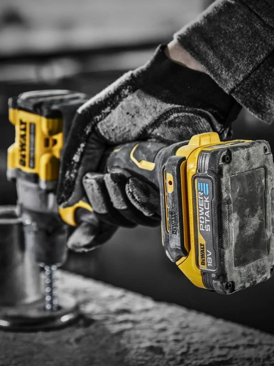 Mano sujetando una herramienta eléctrica Dewalt en un entorno de carpintería.