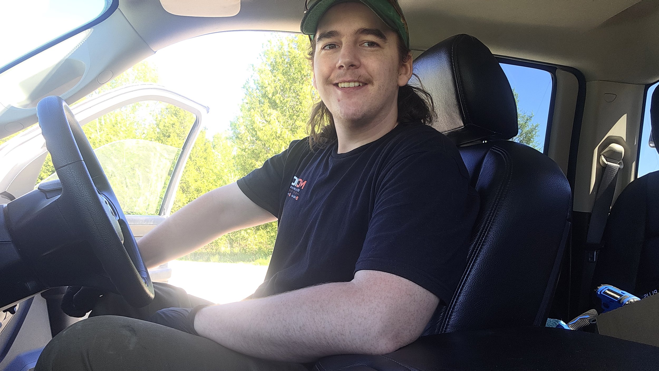 Owner-operator of McMo Demo & Junk Removal sitting in company work truck ready to assist customers throughout Georgina and surrounding areas.
