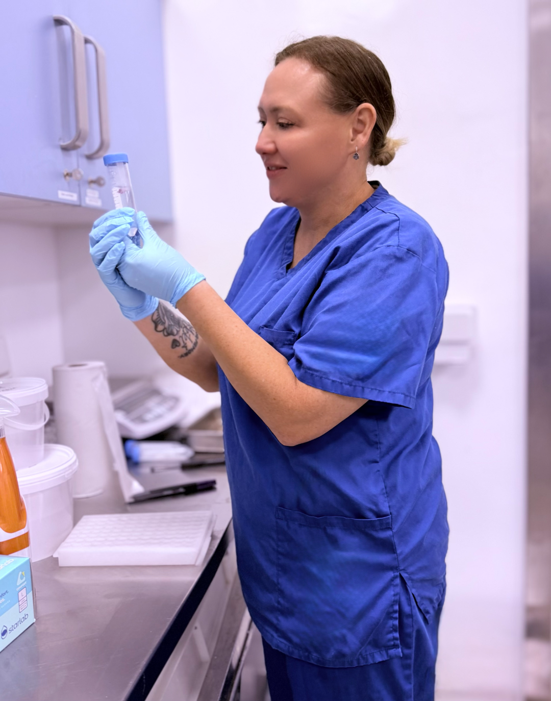 Nikki Morrison examining a sample tube during Animal Welfare Science laboratory practical work.