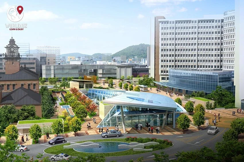 A city park with modern glass structures, trees, people walking, and surrounding tall buildings.