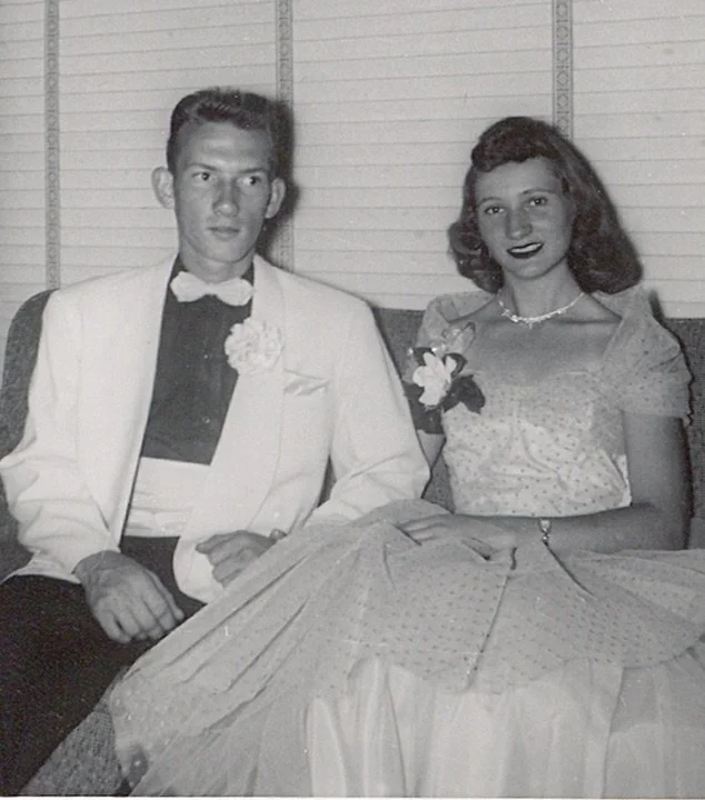 A vintage black-and-white photo of a young man and woman sitting together, dressed formally, likely at a special event or dance, with a lined wall background. My Mom and Dad on Prom date. Richard and Gloria Sumner