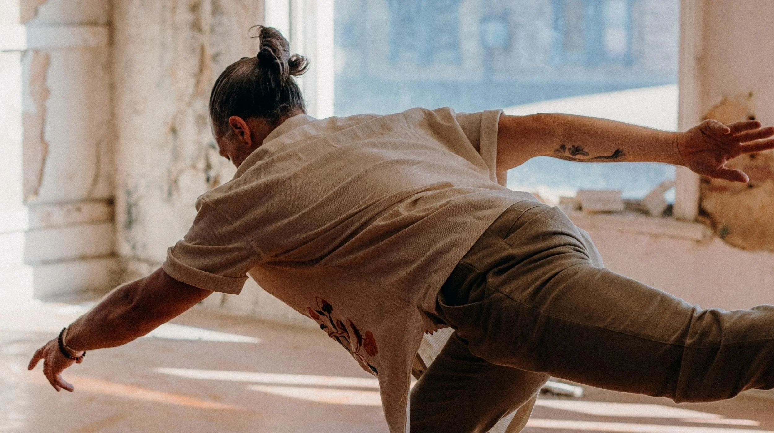A man in a white shirt mid yoga pose