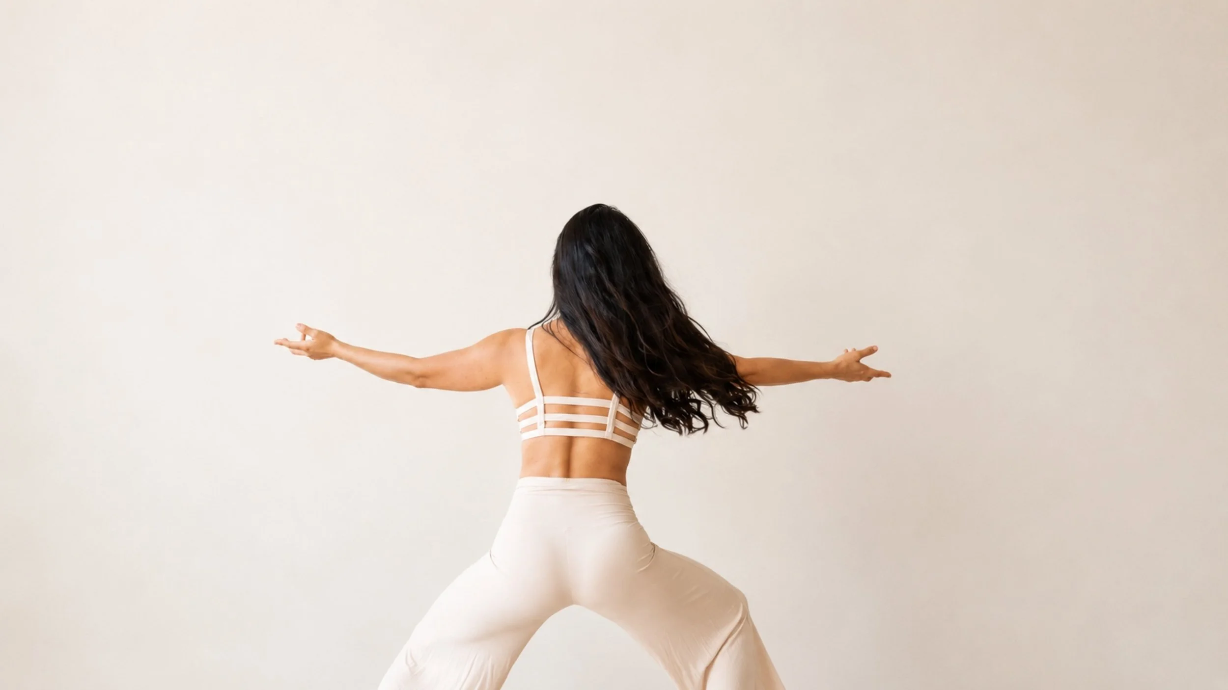 a womans back with both her hands outstretched